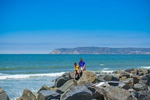 couple on rocks at coronado beach in san diego