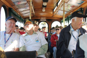 veterans sitting inside old town trolley vehicle during veterans day parade in san diego