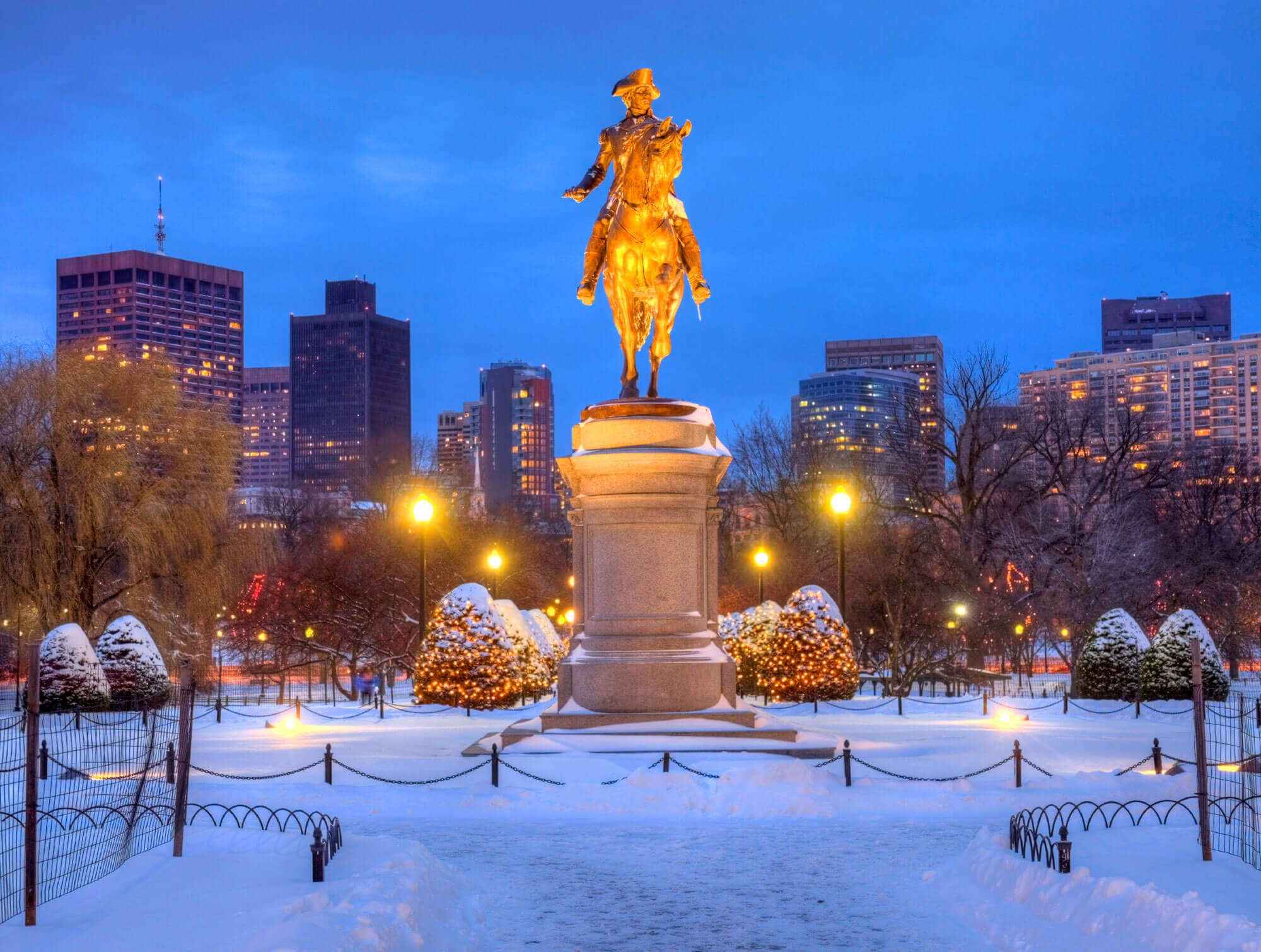 lit statue of George Washington on horseback surrounded by fallen snow in the Public Garden, Boston, MA