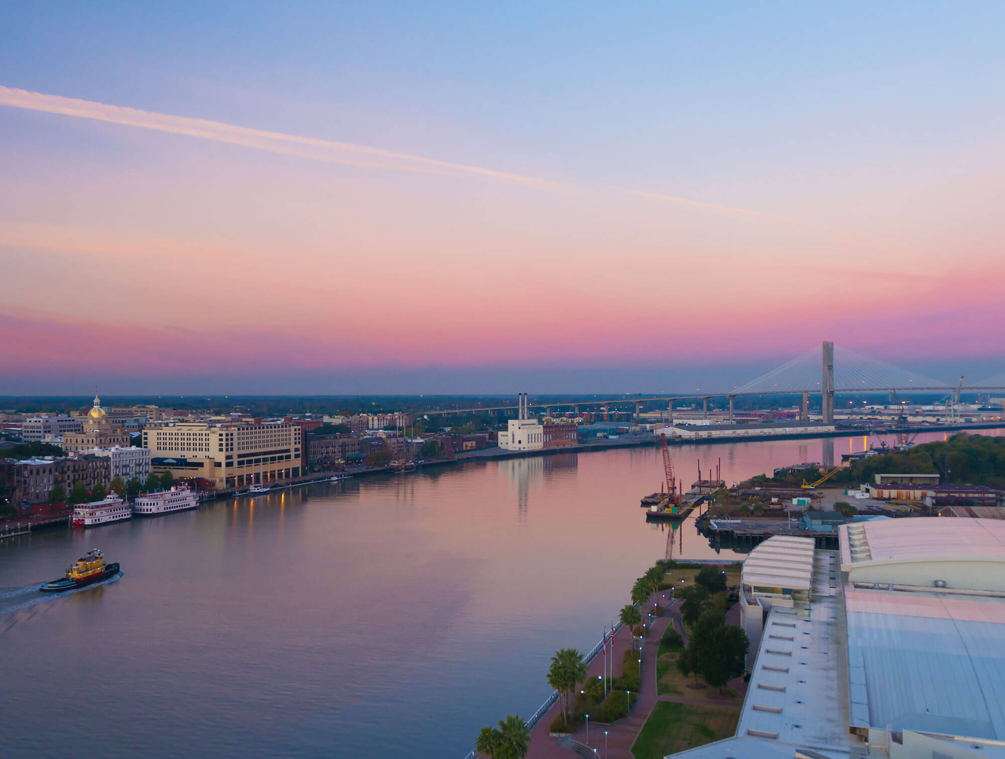A view of the Savannah River at dusk with the Talmadge Memorial Bridge in the background