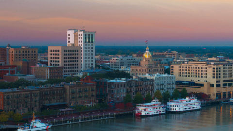 A view of downtown Savannah, GA from the Savannah River where two riverboats and a Coast Guard cutter are harbored