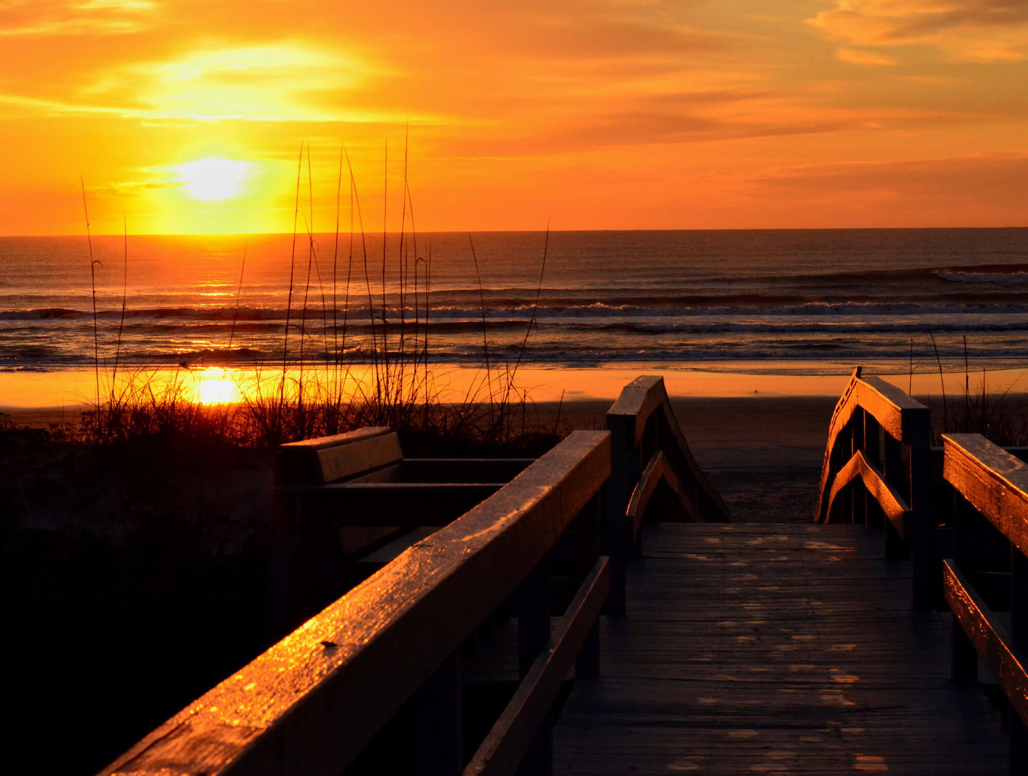 Image of a walkway leading to a beach reflected in an orange light in St. Augustine, FL