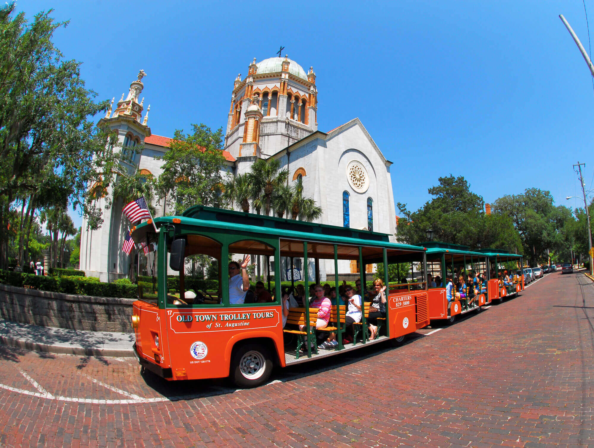 The Old Town Trolley giving a tour in front of the Memorial Presbyterian Church built by Henry Flagler in St. Augustine, FL