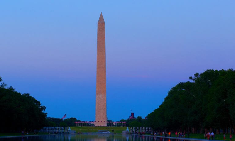 Head on view of the Washington Monument across the Reflecting Pool in Washington DC at night