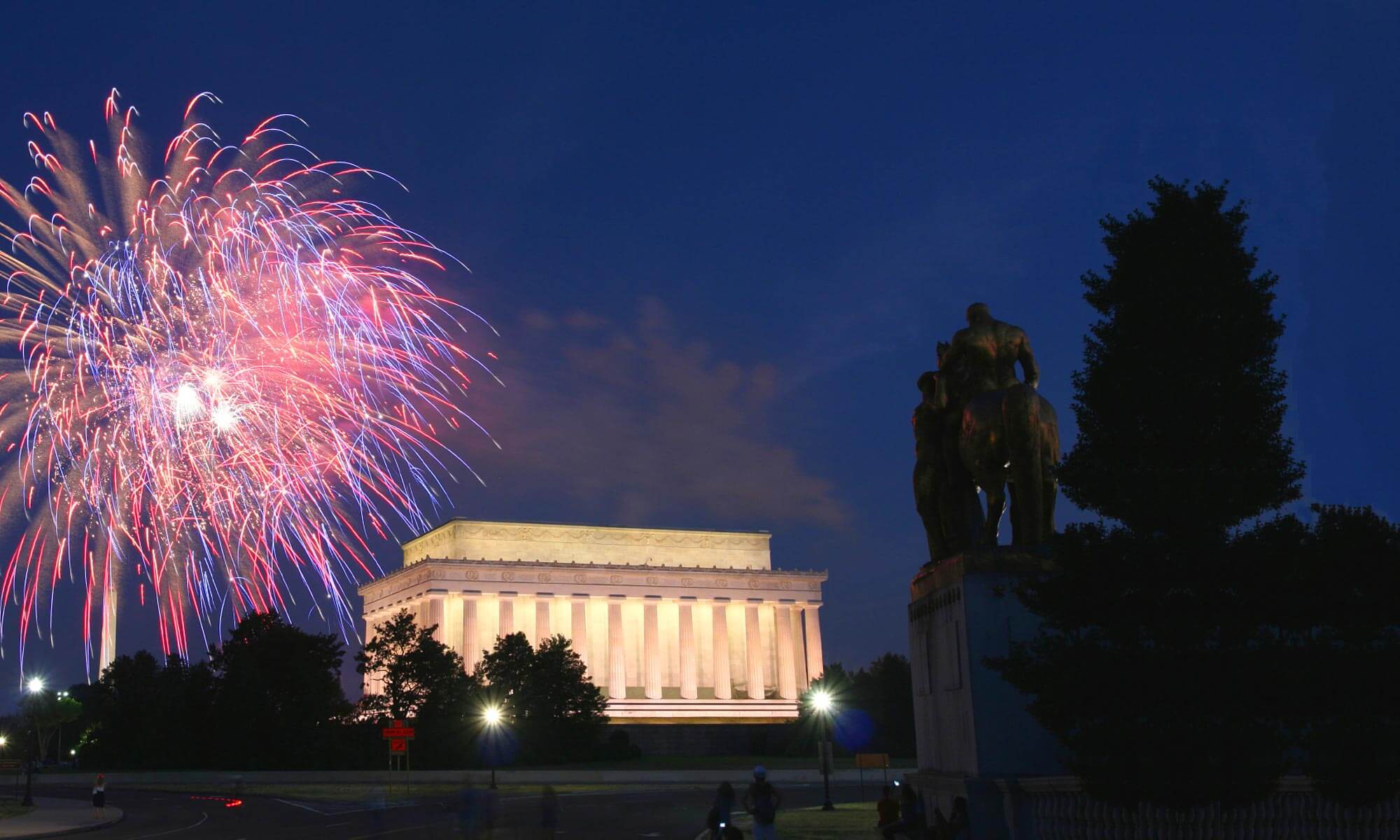 Picture taken from the foot of the Arlington Memorial Bridge of the Lincoln Memorial at night along with a fireworks display in Washington DC