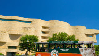 Washington DC Museums - An Old Town Trolley driving past the very curvy shapes of the National Museum of the American Indian in Washington DC