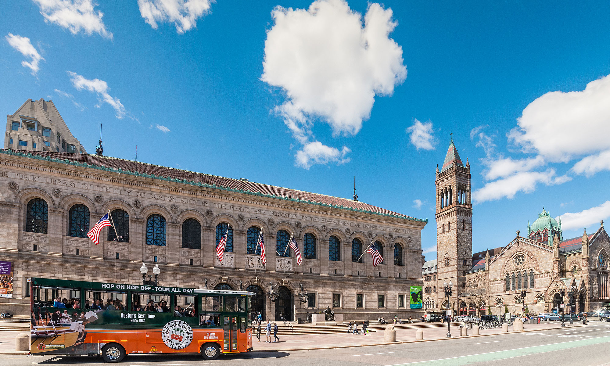 Boston trolley driving past Boston Public Library