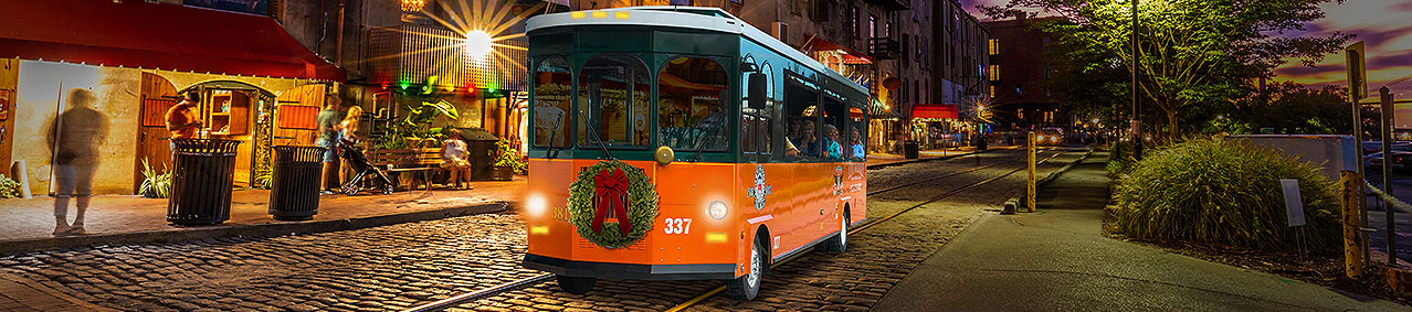 Savannah trolley driving past river street at night