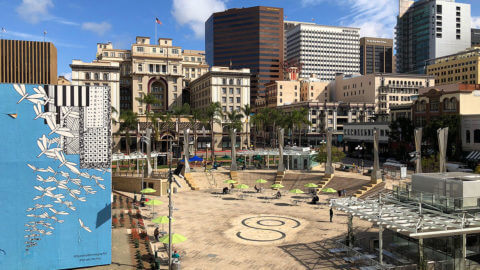 Like an urban village in the middle of a city is Horton Plaza which is a large public space with chairs and tables in the heart of downtown San Diego