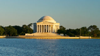 view of Jefferson Memorial made up of a dome and columns sitting on the tidal basin in Washington DC