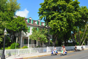 tourists riding scooters in front of Key West Audubon House