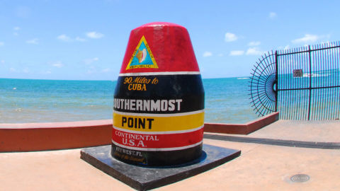 image of southernmost point landmark in front of the water