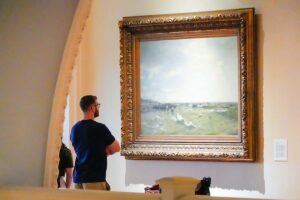 guest viewing painting at Lightner Museum in St. Augustine