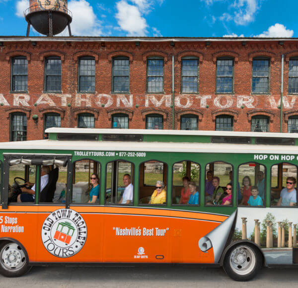 Old Town Trolley Tour passing in front of the old brick Marathon Automobile Company building