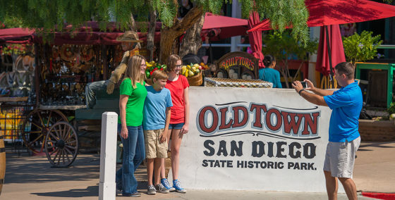 Family standing next to sign that reads 'old town san diego state historic park'