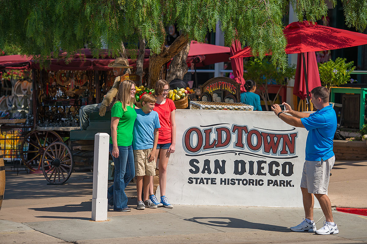 Family standing next to sign that reads 'old town san diego state historic park'