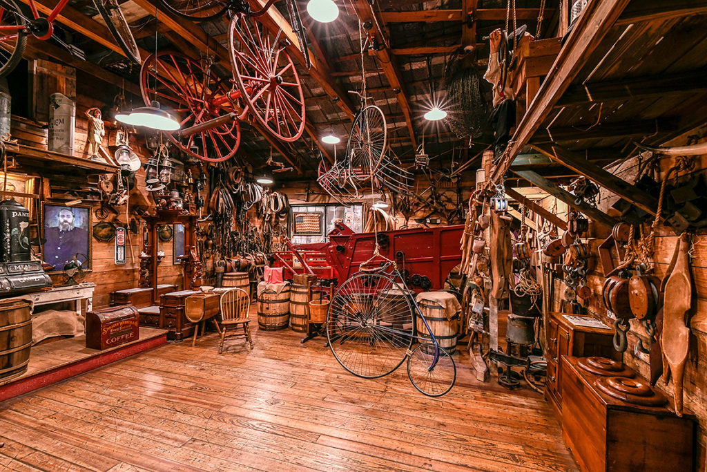 interior of oldest store museum featuring old bikes, barrels, portraits, trunks and may more items