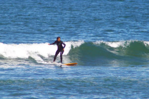 Girl surfing off San Diego coast