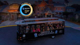 Night time picture of St. Augustine ghost trolley in front of the Old Jail and a Round logo that reads USA Today 10 BEST READERS' CHOICE 2019' and around logo, the words 'BEST GHOST TOUR, #5 - GHOSTS & GRAVESTONES TOUR'