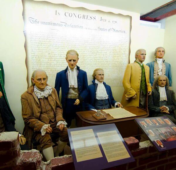 Wax likenesses of the signers of the Declaration of Independence in front of a large reproduction of the declaration itself inside Potter's Wax Museum in St. Augustine