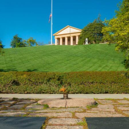 Image of the flat stones and memorial plaque dedicated to John F. Kennedy that surrounds the Eternal Flame in the Arlington National Cemetery