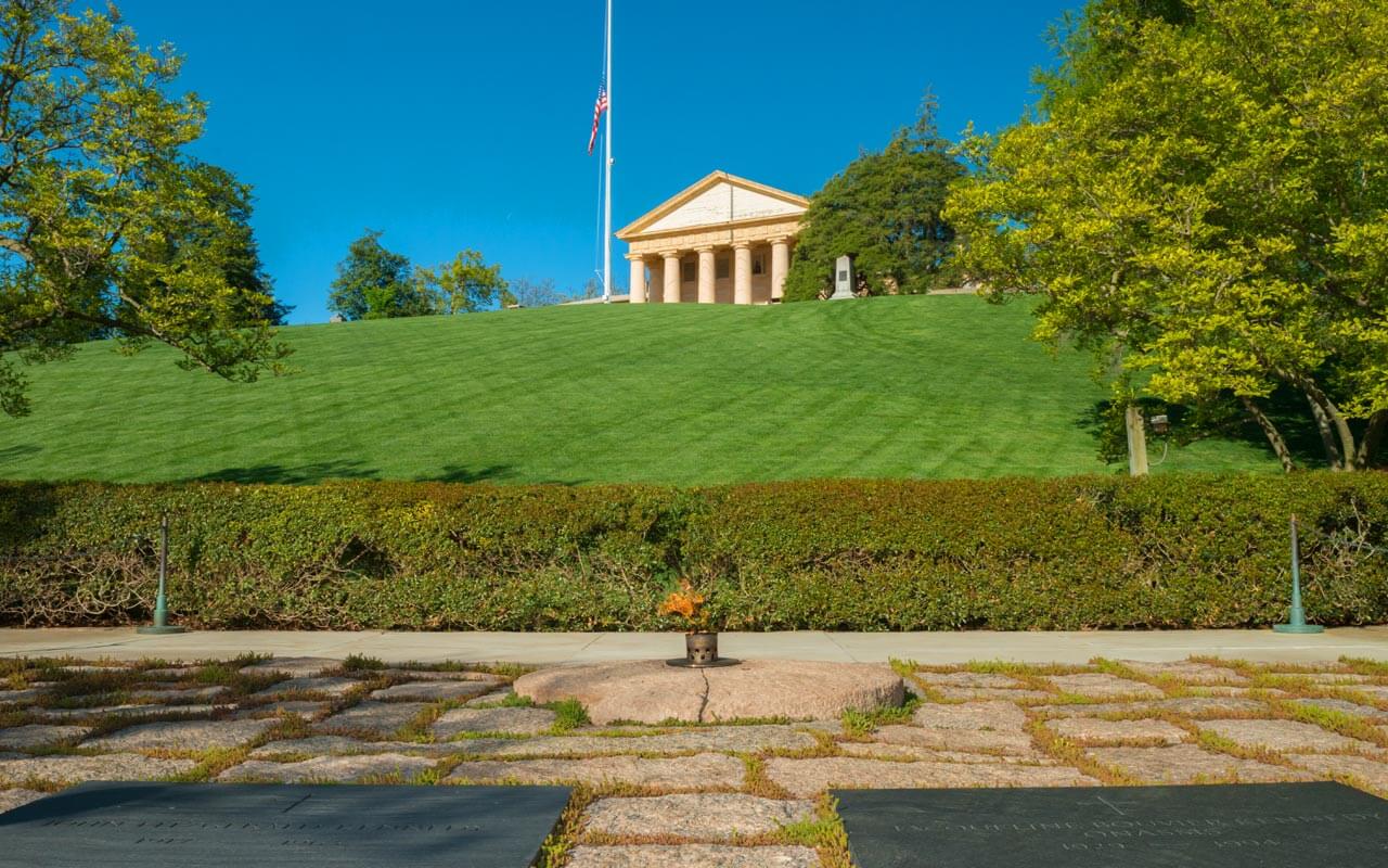 Image of the flat stones and memorial plaque dedicated to John F. Kennedy that surrounds the Eternal Flame in the Arlington National Cemetery