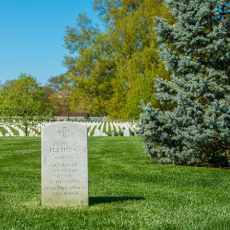 Close-up of the headstone General John J. Pershing overlooking rows of white headstones in Arlington National Cemetery