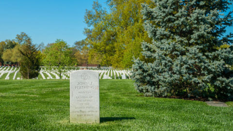 Close-up of the headstone General John J. Pershing overlooking rows of white headstones in Arlington National Cemetery