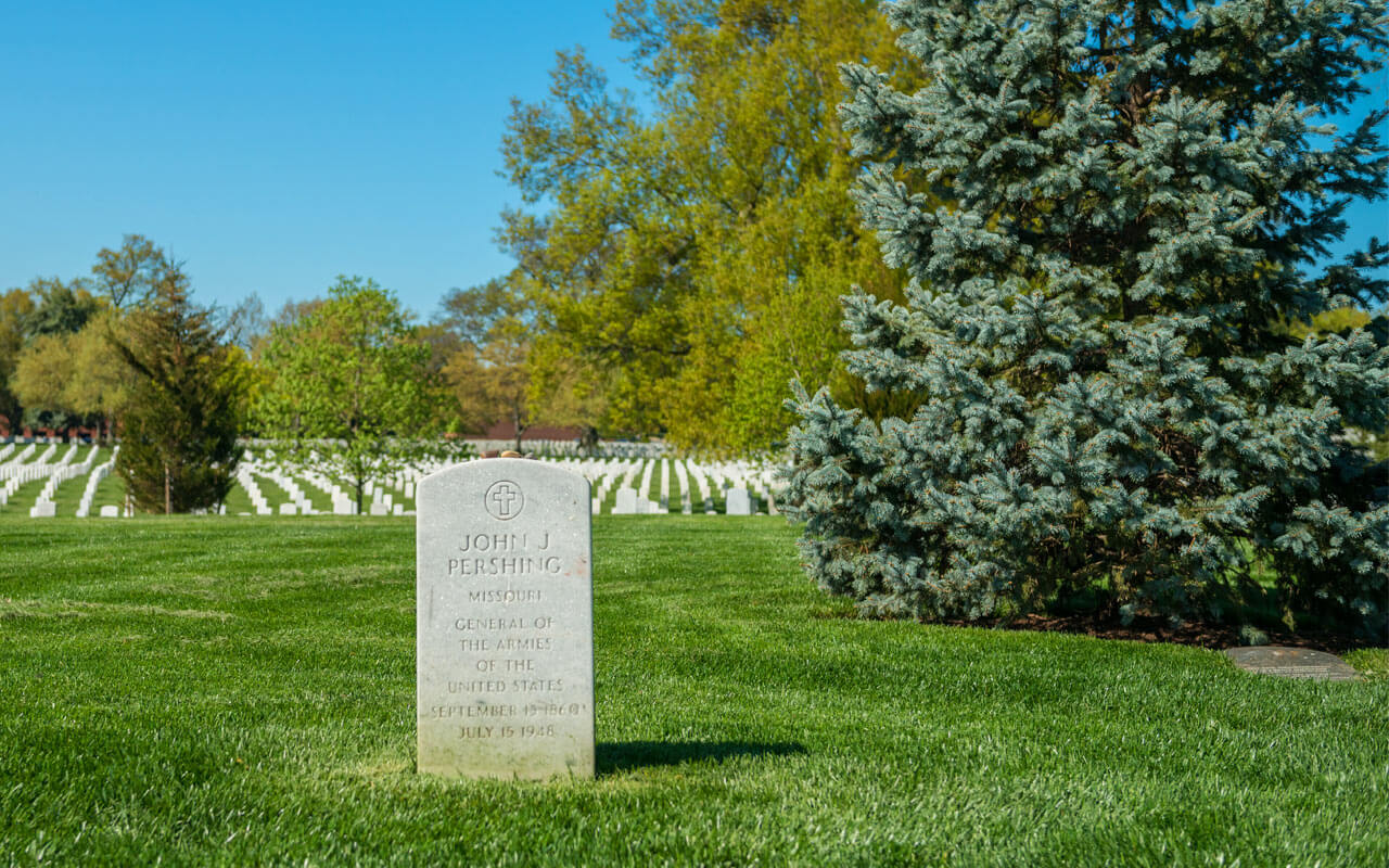 Close-up of the headstone General John J. Pershing overlooking rows of white headstones in Arlington National Cemetery