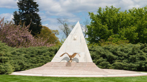 The U.S. Coast Guard Memorial which appears as a triangular slab of marble emblazoned with the Coast Guard Crest accompanied by a bronze eagle in Arlington National Cemetery