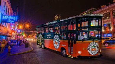 old town trolley vehicle driving down nashville street at night during nashville night tour