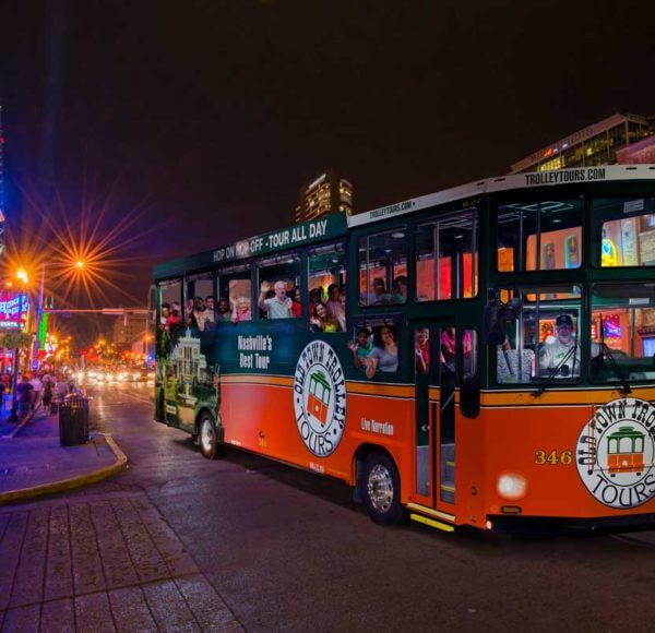 old town trolley vehicle driving down nashville street at night during nashville night tour