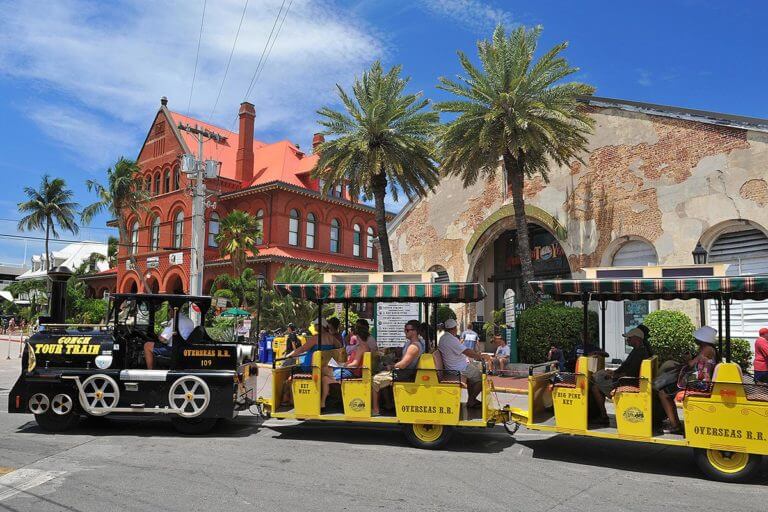 conch tour train driving past customs house