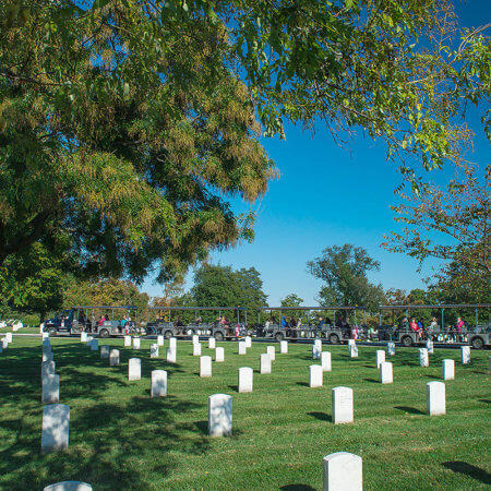 picture of arlington national cemetery tours vehicle driving past rows of tombstones