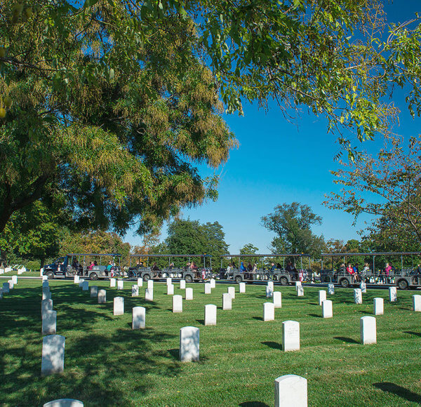 picture of arlington national cemetery tours vehicle driving past rows of tombstones