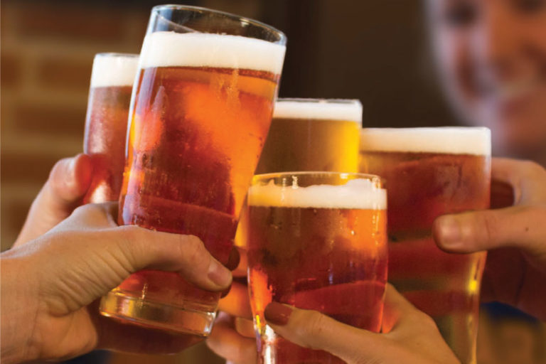 picture of hands raising glasses full of beer