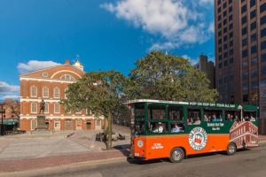Boston trolley driving past faneuil hall