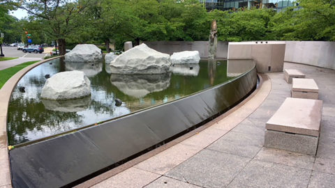 picture showing Japanese American Memorial outdoors with fountain, rocks and benches and trees in the background