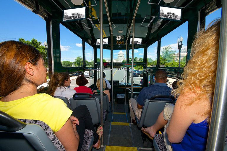 interior of trolley showings guests looking out large windows showing US capitol