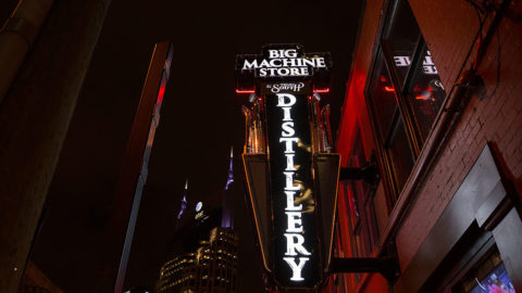 night time picture showing a neon sign that reads 'Big Machine Store, the Tenn South Distillery'