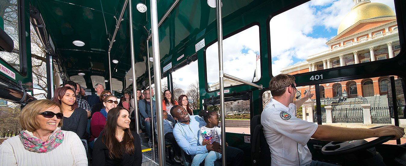 interior of boston trolley with guests looking out the windows at state house
