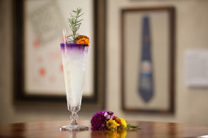 an alcoholic beverage and flowers on a table