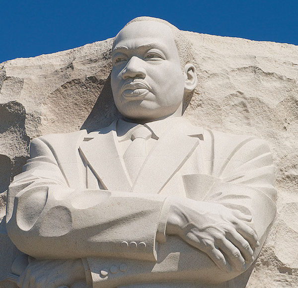 Picture of top of Martin Luther King Jr. Memorial showing the top half of Martin Luther King standing with arms crossed and carved out of a large stone