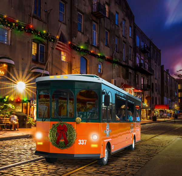 Savannah trolley driving past river street at night during a holiday tour