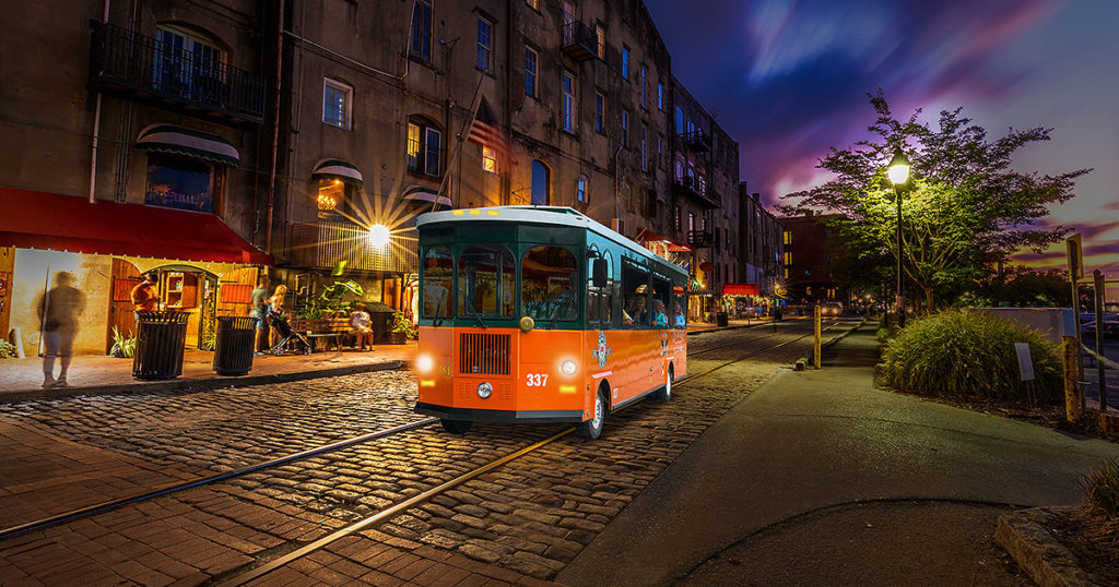 Savannah trolley driving past river street at night