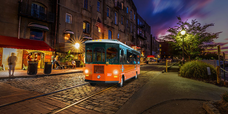 Savannah trolley driving past river street at night