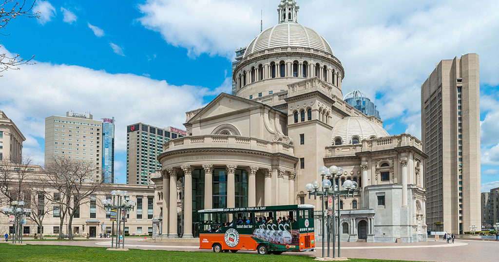 Boston trolley driving past Christian Science Plaza complete with a dome