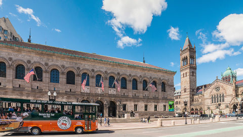 old town trolley boston driving in front of the boston public library