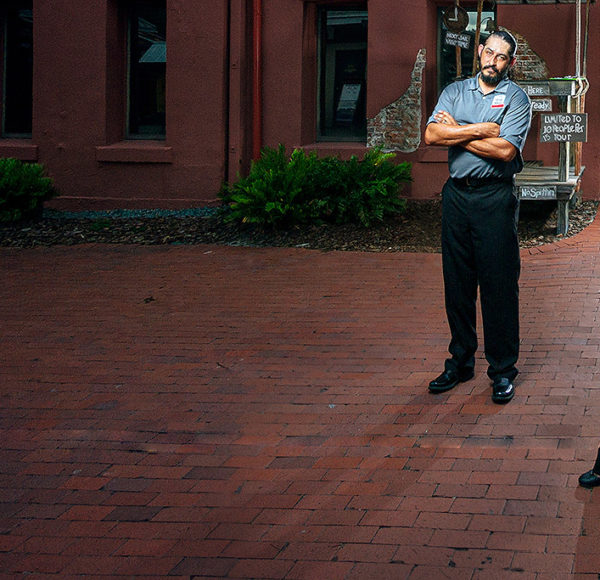 three tour guides standing outside St. Augustine Old Jail at night