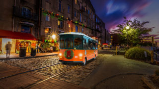 Savannah trolley driving past river street at night